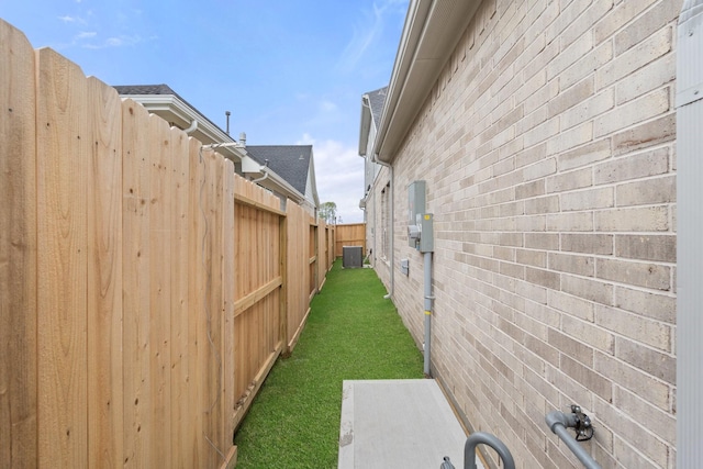 view of yard featuring fence and central air condition unit