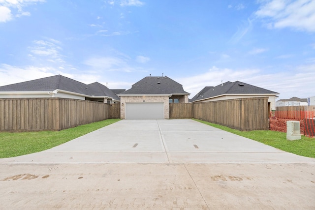 exterior space with a garage, brick siding, fence, and driveway