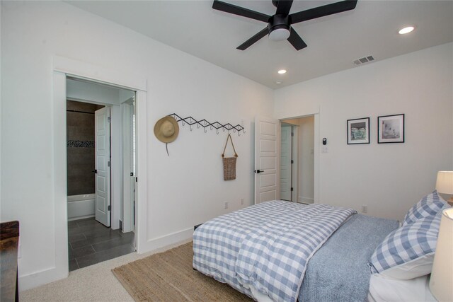 tiled bedroom featuring connected bathroom and ceiling fan