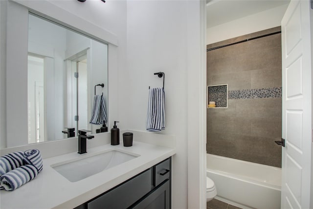 full bathroom featuring tiled shower / bath combo, vanity, and toilet