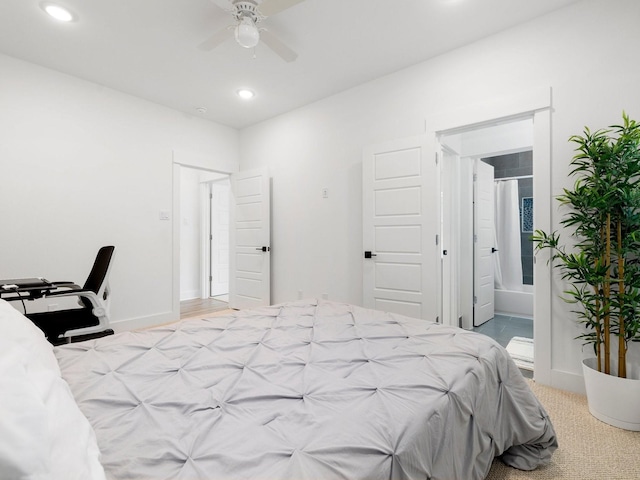 bedroom featuring ceiling fan, light colored carpet, and ensuite bathroom