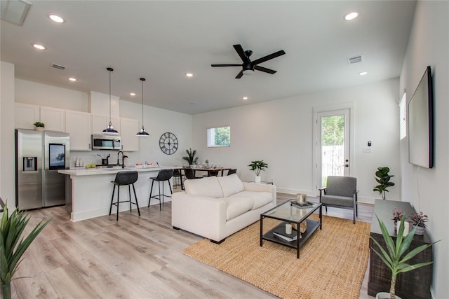 living room featuring ceiling fan and light hardwood / wood-style flooring