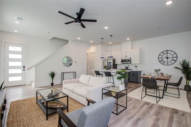 living room featuring ceiling fan and light hardwood / wood-style floors