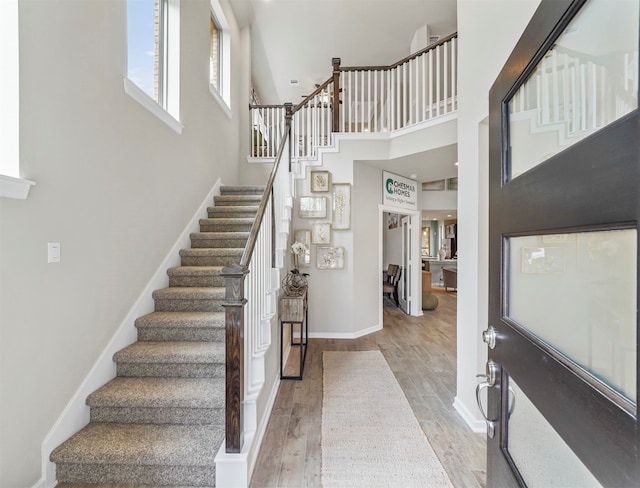 foyer with a high ceiling and light hardwood / wood-style floors