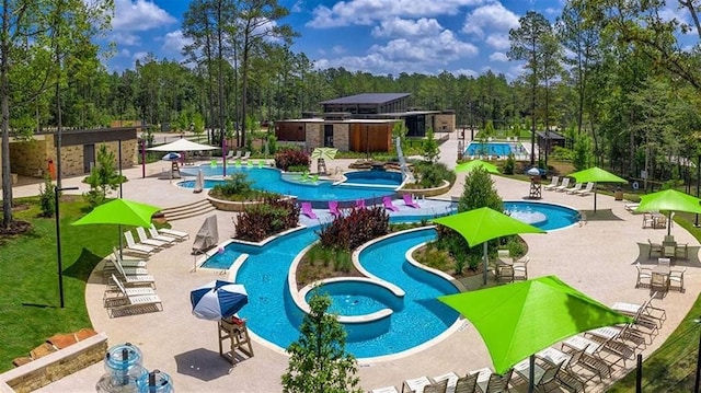 view of property's community with a patio area and a pool with hot tub