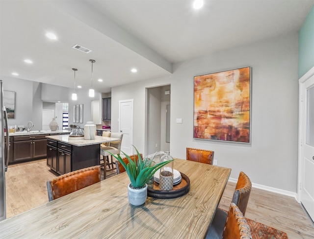 dining room featuring sink and light hardwood / wood-style floors