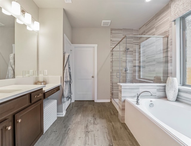 bathroom featuring hardwood / wood-style floors, separate shower and tub, and vanity