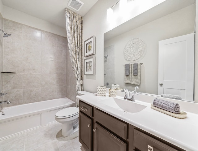 full bathroom featuring tile patterned floors, tiled shower / bath, toilet, and vanity