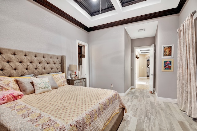 bedroom with coffered ceiling, crown molding, and light hardwood / wood-style floors