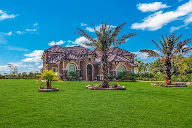 mediterranean / spanish-style home featuring a front yard