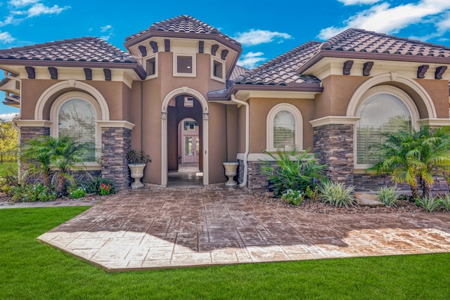 mediterranean / spanish-style house featuring a front lawn