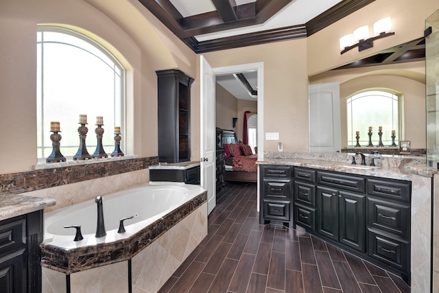 bathroom with crown molding, coffered ceiling, vanity, and tiled bath