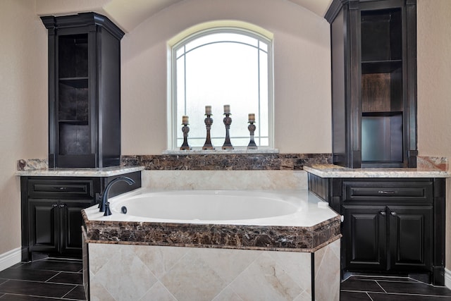 bathroom with tiled tub, vanity, and tile patterned floors