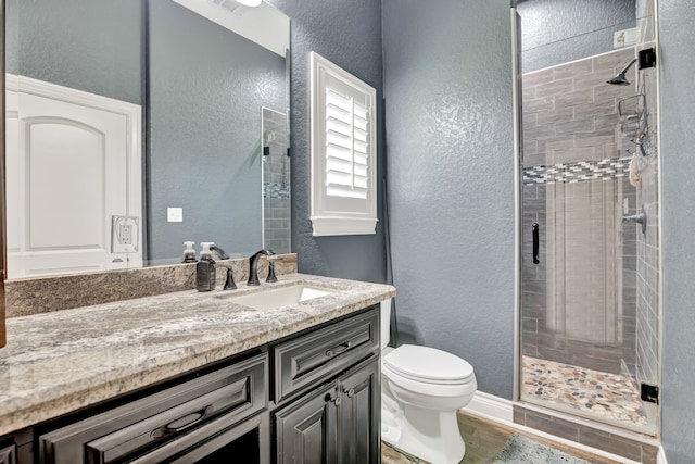 bathroom with an enclosed shower, vanity, wood-type flooring, and toilet