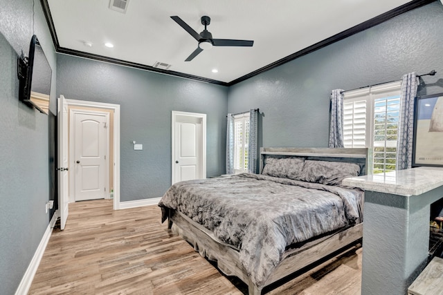 bedroom with ceiling fan, crown molding, multiple windows, and light hardwood / wood-style floors