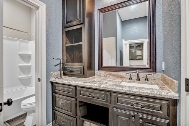 full bathroom with  shower combination, vanity, and toilet