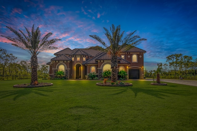 mediterranean / spanish house featuring a yard and a garage