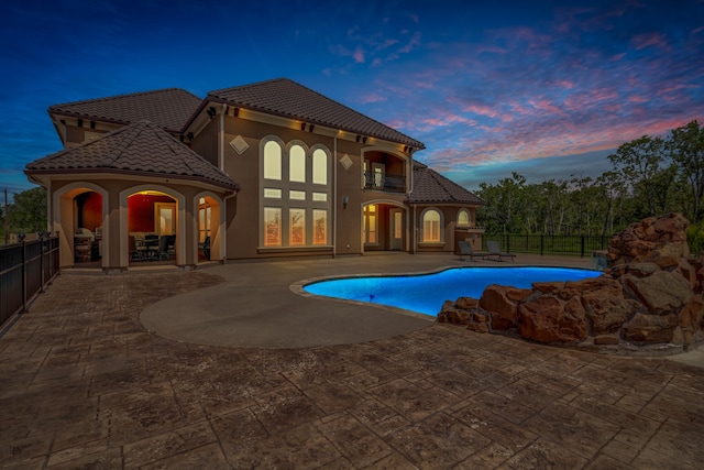 pool at dusk with a patio