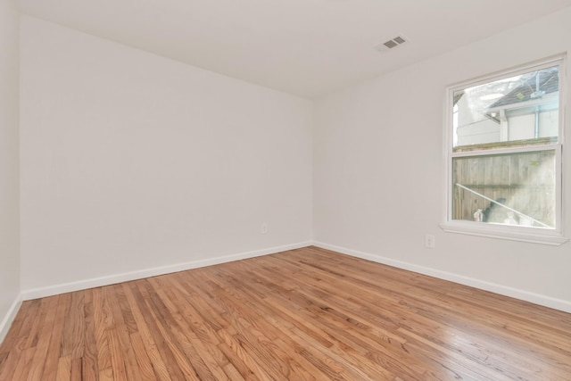 empty room with light hardwood / wood-style flooring and plenty of natural light