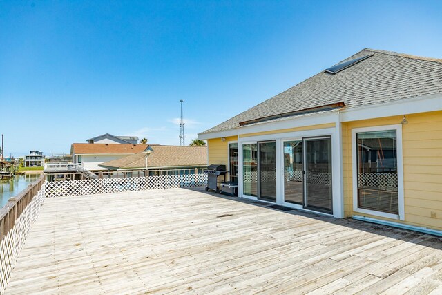 wooden deck featuring a grill and a water view