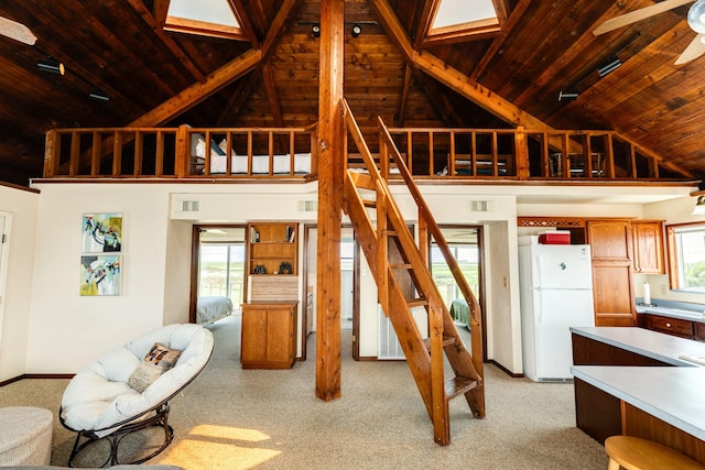 living area with light carpet, high vaulted ceiling, wooden ceiling, baseboards, and stairs