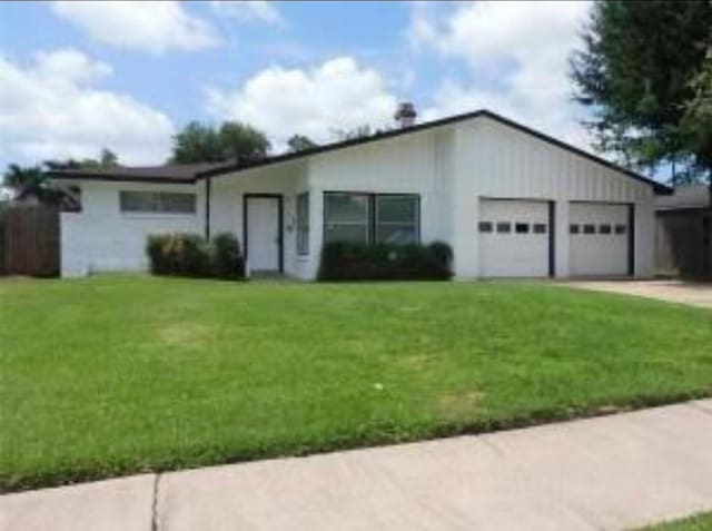 single story home featuring a front yard and a garage