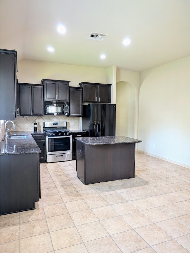 kitchen with decorative backsplash, black appliances, light tile patterned flooring, a center island, and sink