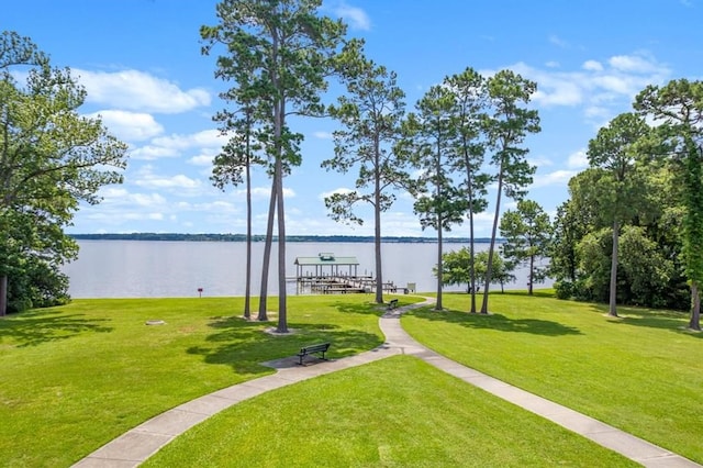 view of community with a yard and a water view