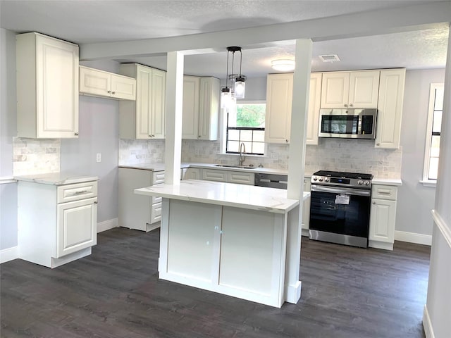 kitchen featuring pendant lighting, dark hardwood / wood-style floors, stainless steel appliances, and sink