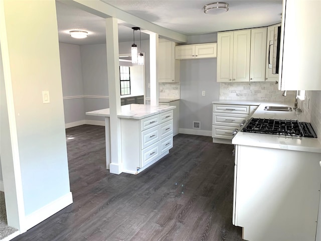 kitchen with hanging light fixtures, tasteful backsplash, and dark wood-type flooring