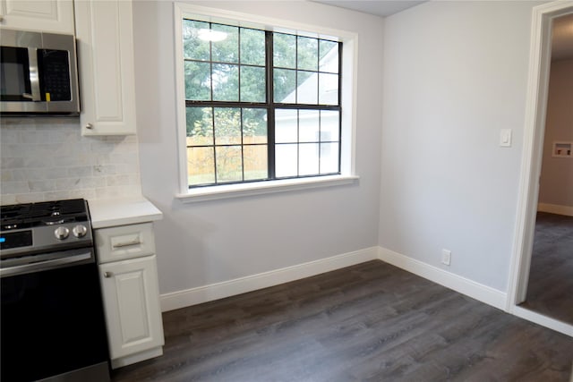 kitchen featuring appliances with stainless steel finishes, plenty of natural light, dark wood-type flooring, and tasteful backsplash