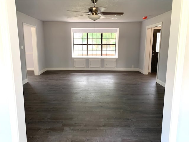 empty room featuring ceiling fan and dark hardwood / wood-style floors