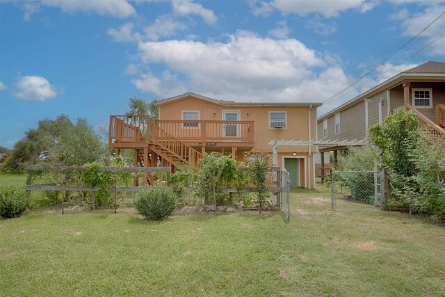 back of property with a pergola, a deck, and a lawn