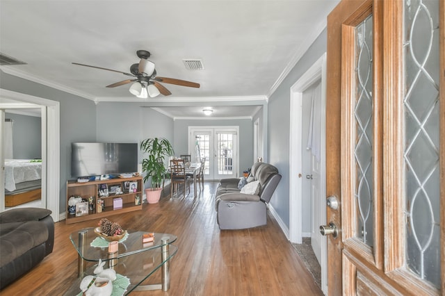 living room featuring ceiling fan, french doors, wood-type flooring, and ornamental molding