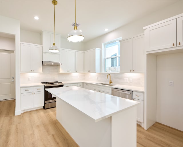 kitchen with white cabinetry, pendant lighting, stainless steel appliances, and sink