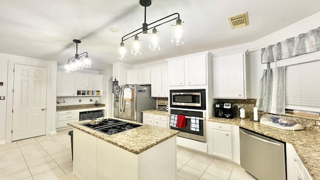 kitchen with light stone counters, white cabinets, pendant lighting, black appliances, and a center island