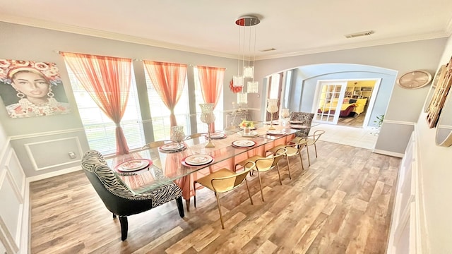 dining room with hardwood / wood-style floors and crown molding