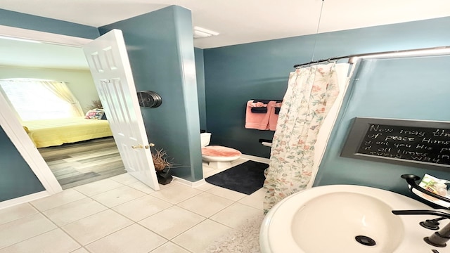 bathroom with tile patterned floors, sink, and curtained shower