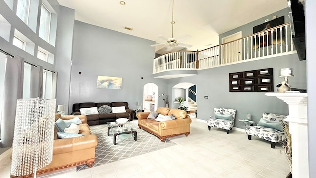 living room with a towering ceiling and ceiling fan