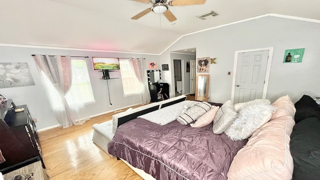 bedroom featuring ornamental molding, vaulted ceiling, light hardwood / wood-style floors, and ceiling fan