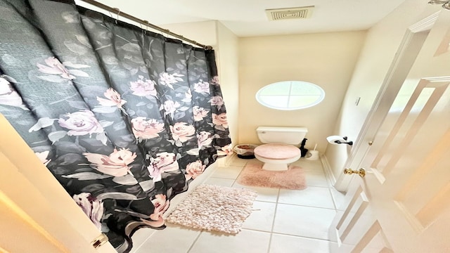 bathroom with walk in shower, tile patterned flooring, and toilet