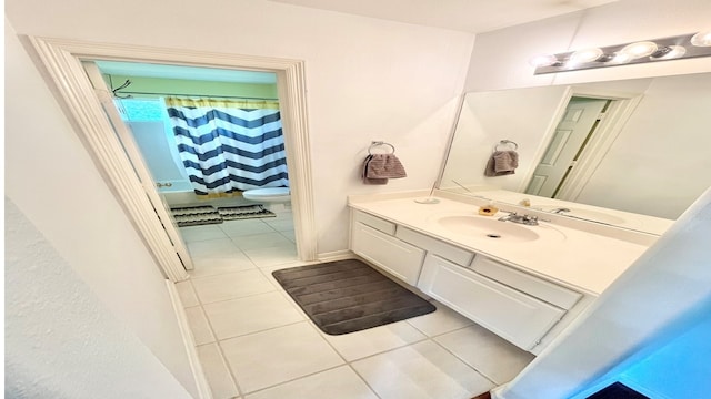 bathroom with tile patterned flooring, a shower with curtain, vanity, and toilet