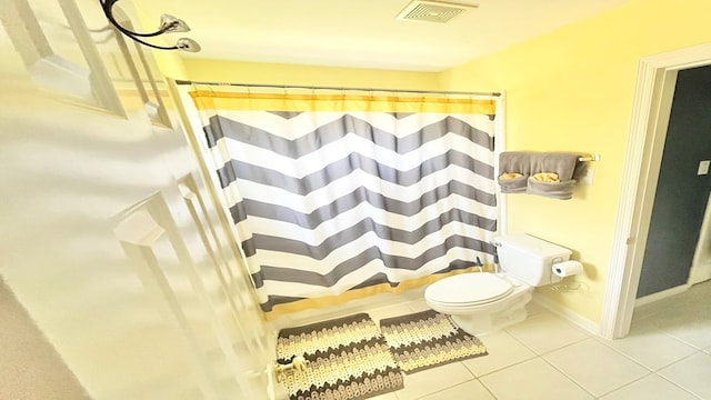 bathroom featuring a shower with shower curtain, tile patterned floors, and toilet