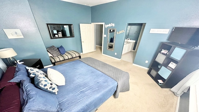 bedroom with ensuite bathroom and carpet flooring