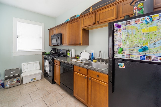 kitchen with black appliances, sink, and light tile patterned floors