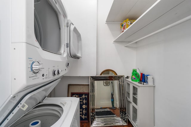 clothes washing area featuring stacked washing maching and dryer