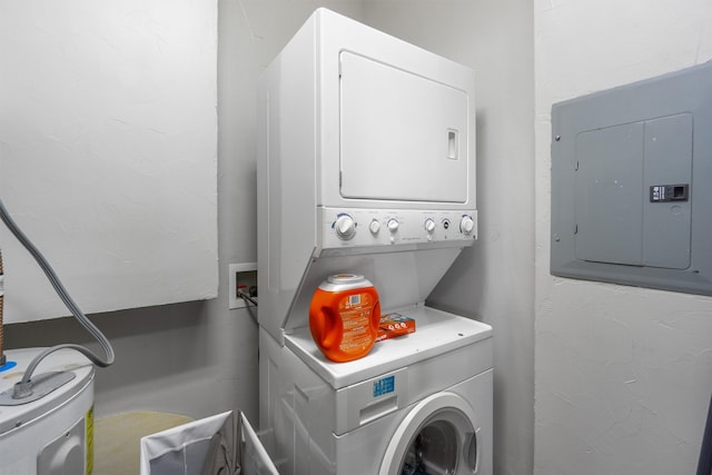 laundry area with water heater, electric panel, and stacked washing maching and dryer