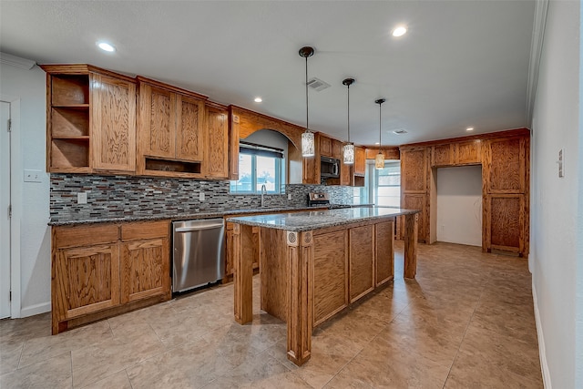 kitchen featuring a kitchen island, appliances with stainless steel finishes, tasteful backsplash, ornamental molding, and dark stone counters