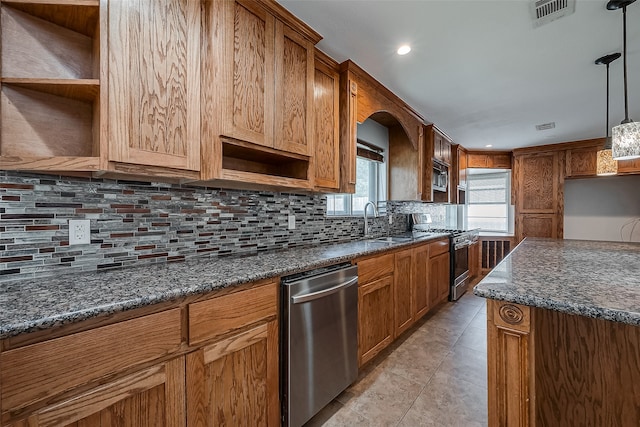 kitchen with backsplash, light tile patterned floors, appliances with stainless steel finishes, sink, and pendant lighting