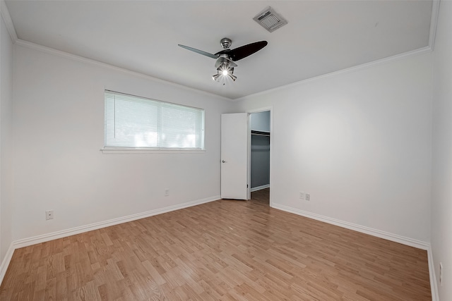 empty room with ornamental molding, light hardwood / wood-style flooring, and ceiling fan